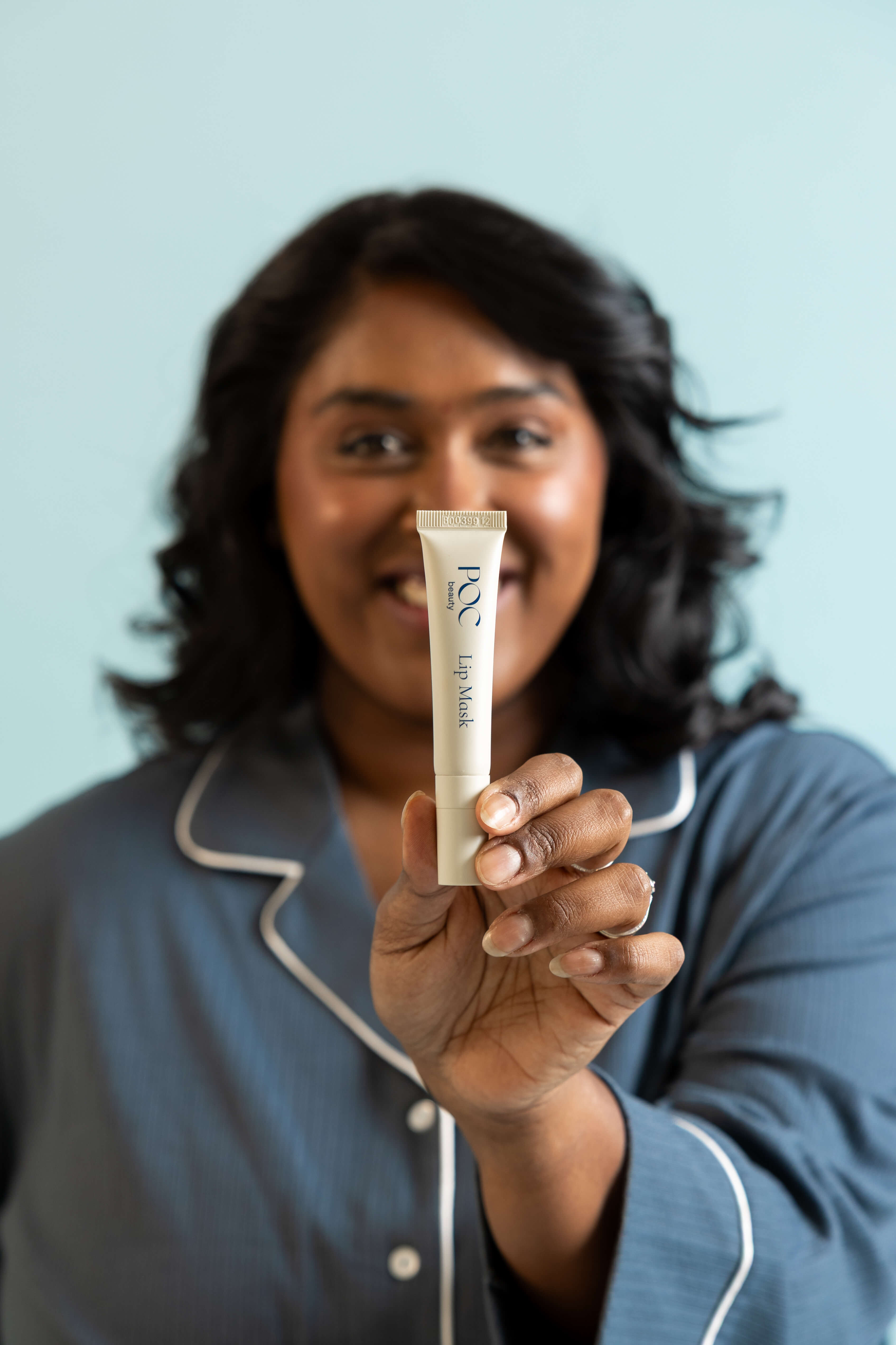 beautiful woman of colour holding poc beauty lip mask